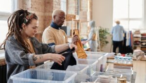 Personer sorterar kläder och förnödenheter i en second hand-verksamhet
