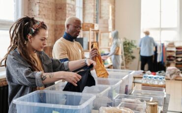 Personer sorterar kläder och förnödenheter i en second hand-verksamhet
